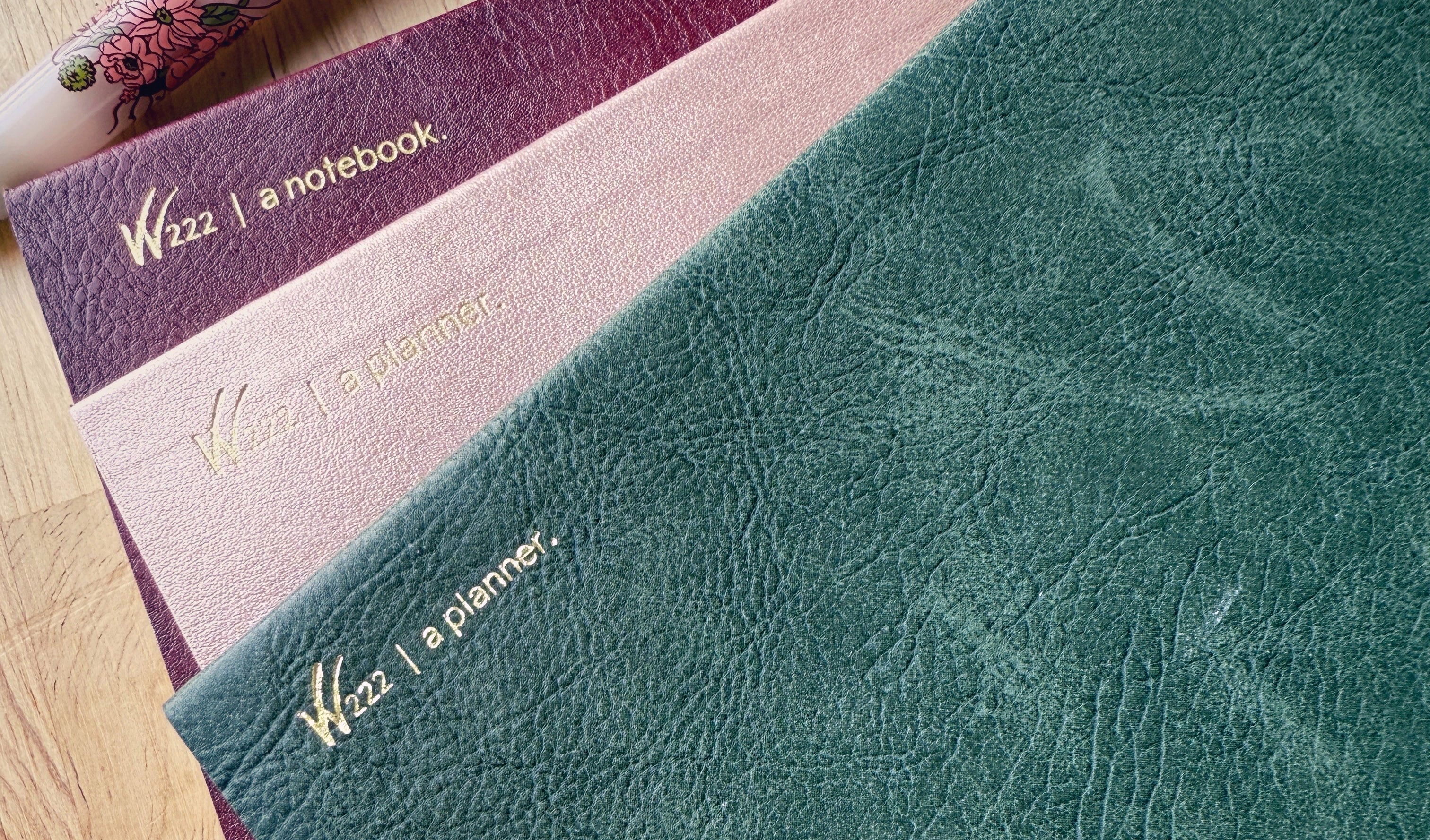 2026 Wonderland 222 planners and notebook.  Alpenglow, North Slope and Lingonberry colors next to a Sailor Pro Gear slim Ancora fountain pen in Vintage Boquet