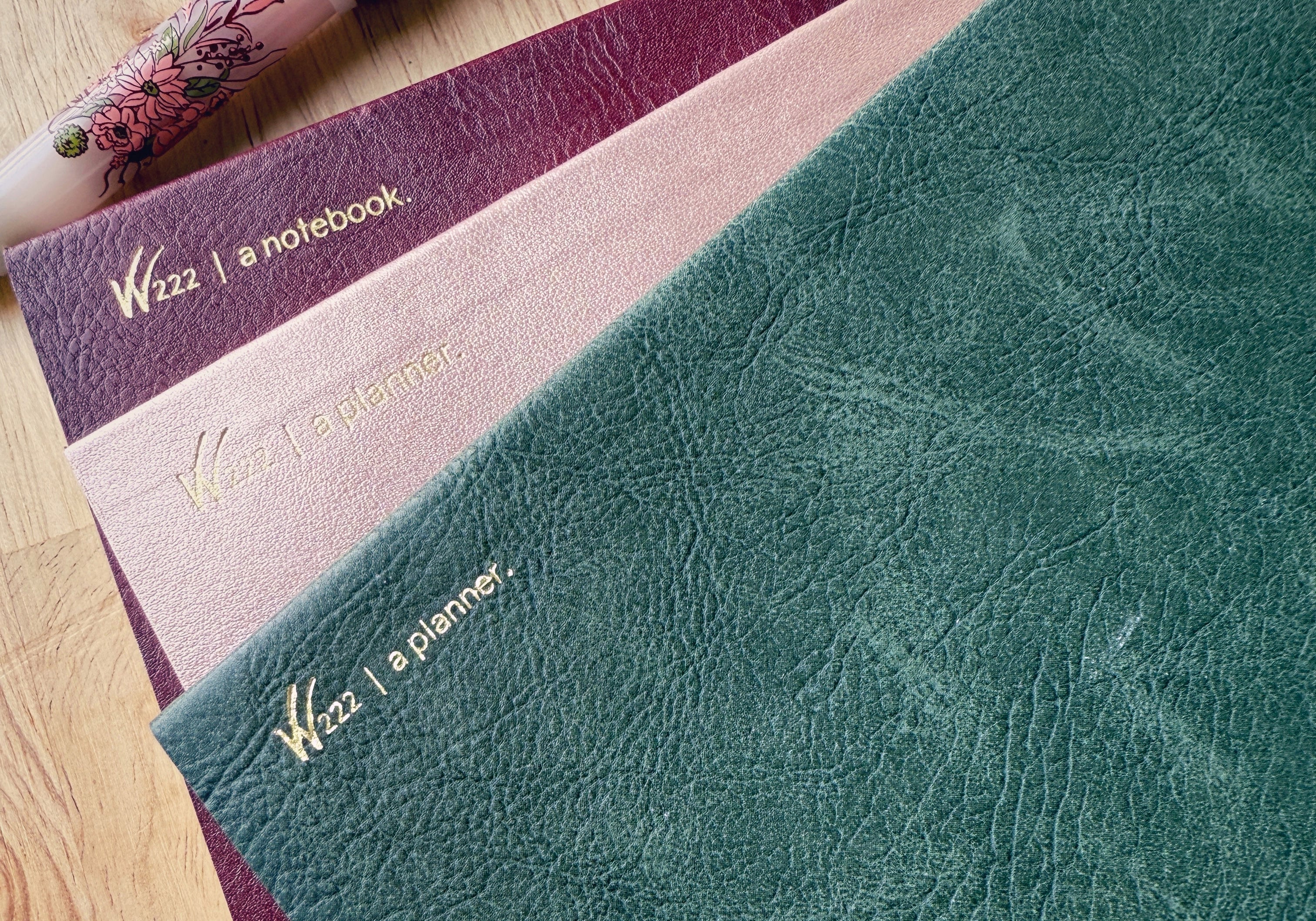2026 Wonderland 222 planners and notebook.  Alpenglow, North Slope and Lingonberry colors next to a Sailor Pro Gear slim Ancora fountain pen in Vintage Boquet